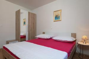 een slaapkamer met een groot wit bed met een rode deken bij Luxury apartment Nora in Podstrana