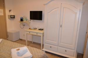 a bedroom with a large white cabinet and a desk at Rio Groppo Guesthouse in Manarola
