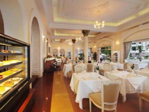 a restaurant with white tables and chairs and a buffet at Hotel Continental Saigon in Ho Chi Minh City