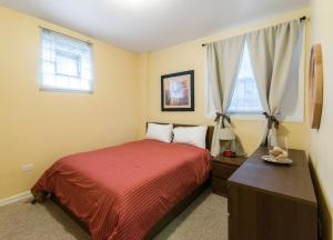 a bedroom with a bed and a dresser and two windows at 1549 North Maplewood Avenue in Chicago