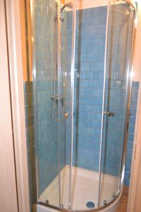 a bathroom with a shower with blue tiles at Rio Groppo Guesthouse in Manarola