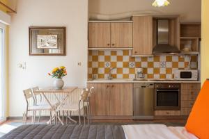 een keuken met een tafel en stoelen in een kamer bij Evelia Apartment in Galatás