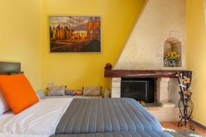 - une chambre avec un lit et une cheminée dans l'établissement Evelia Apartment, à Galatás