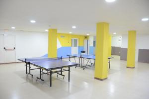 two ping pong tables in a room with yellow pillars at Alberg Coma-ruga Xanascat in Comarruga