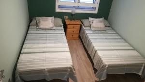 dwa łóżka w sypialni z komodą i oknem w obiekcie Bed & Breakfast Descanso y Relax w mieście Puerto del Rosario