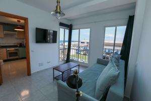 ein Wohnzimmer mit Couch und Blick aufs Meer in der Unterkunft La Buena Vida, by Comfortable Luxury in Corralejo