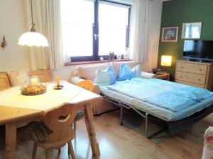 a living room with a bed and a table at Wohlfühlapartment Dachsteinblick in Bad Goisern