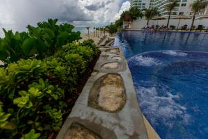 a row of stepping stones next to a swimming pool at Condominio Girasol OceanView in Cancún