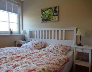 a bedroom with a bed and two tables and a window at Landhaus von Frieling in Soltau