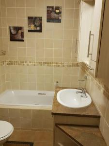 a bathroom with a sink and a tub and a toilet at Ocean View Villas Unit G02 in Port Edward