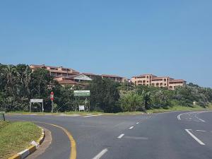 an empty road in front of a building with a stop sign at Ocean View Villas Unit G02 in Port Edward