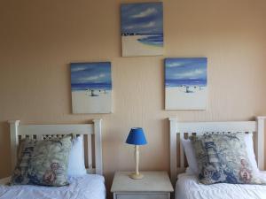 a bedroom with two beds and paintings on the wall at Ocean View Villas Unit G02 in Port Edward +13 photos