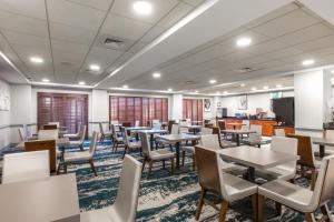 a dining room with tables and chairs at Wingate by Wyndham Charlotte Concord Mills/Speedway in Concord