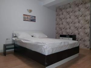 1 dormitorio con 1 cama grande con sábanas blancas en ingrid, en Mangalia