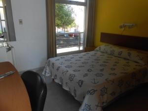 a small bedroom with a bed and a window at HOTEL 25 DE MAYO in Fray Bentos