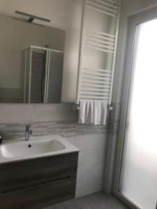 bagno con lavandino e specchio di Gioema a Borgo Vodice