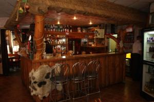 a bar with four stools at a bar with a cow on it at Dom Litewski in Sejny