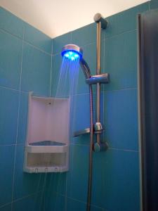 La salle de bains est pourvue d'une douche et d'un mur bleu. dans l'établissement Bed & Breakfast LA TERRAZZA, à Latina
