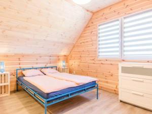 a bedroom with a bed in a wooden wall at Domki Anchor in Lubiatowo