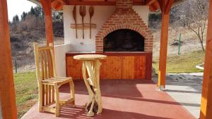 einen Tisch und einen Stuhl auf einer Veranda mit einem Backofen in der Unterkunft GardenLux Sarajevo in Sarajevo