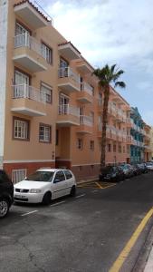 un coche blanco estacionado frente a un edificio en Casa Patrizia Playa San Juan, en Guía de Isora
