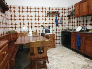 a kitchen with a table and a microwave at La Ozza B&B in Otranto