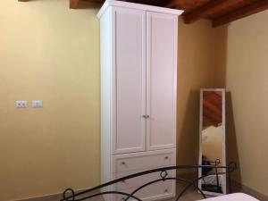 una camera da letto con armadietto bianco e specchio di Villa Alessio a Decimomannu