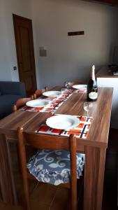 una mesa de madera con platos y una botella de vino en The silence holiday apartment, en Lezzeno