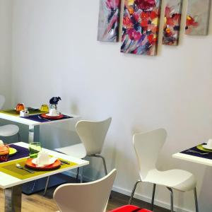 comedor con sillas blancas y mesa en The sisters en Castelsardo