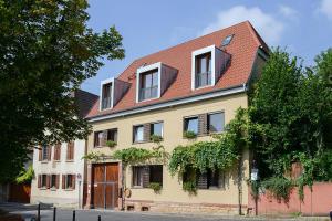 ein großes gelbes Haus mit rotem Dach in der Unterkunft Gästehaus Susanne Pfaffmann in Landau in der Pfalz