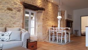 a living room with a white couch and a table and chairs at Le Rousseau Sarlat in Sarlat-la-Canéda