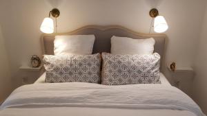 a bedroom with a bed with two pillows and two lights at Le Rousseau Sarlat in Sarlat-la-Canéda