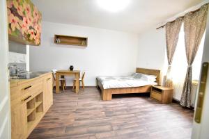a bedroom with a bed and a kitchen with a table at FLH - Central Apartments in Sibiu