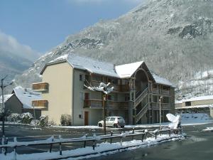 a building in front of a snow covered mountain at Lagrange Vacances Les Pics d'Aran in Luchon