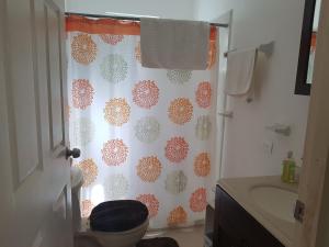 a bathroom with a toilet and a shower curtain at Casa Campestre in Cancún