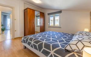 una camera con un letto e un piumone blu e bianco di Apartments Denis 2 a Medulin