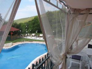 uma vista para uma piscina a partir de uma varanda em Dionysus Village Resort em Mousthéni