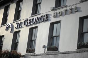 ein Schild an der Seite eines Gebäudes mit Fenstern in der Unterkunft St George Hotel Rochester-Chatham in Chatham