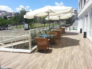 Un patio con mesas, sillas y sombrillas. en Kinorot Hotel, en Tiberíades