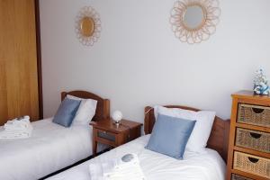 a room with two beds and a mirror on the wall at Marisol Ocean View in Praia da Barra +11 photos