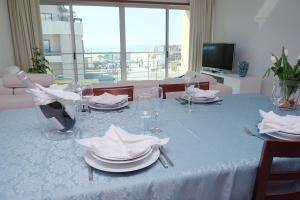 a dining table with plates and wine glasses on it at Marisol Ocean View in Praia da Barra