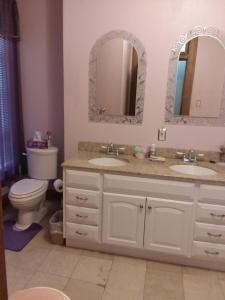 a bathroom with two sinks and a toilet and mirrors at Inn Port D'Vino in Dayton