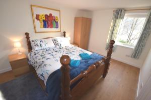 Un dormitorio con una cama con un edredón azul. en Byron Cottage overlooking Loch Goil, en Lochgoilhead