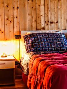 a bedroom with a bed with a wooden wall at Casa Rimasco in Rimasco