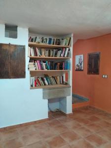 une chambre avec une étagère remplie de livres dans l'établissement Molino Del Búho, à Torre la Cárcel