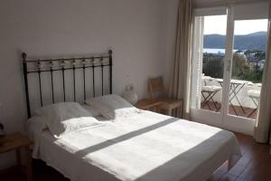 a bedroom with a large bed and a large window at Casa con encanto y jardín amplio en Cadaqués in Cadaqués