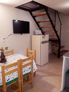 Habitación con mesa, nevera y TV. en Apartamentos Río Uruguay en Colón