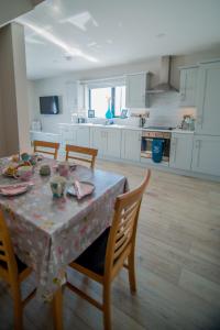 una cucina con tavolo, sedie e tovaglia; di Beside the sea & minutes from Cliffs-Clahane Shore Lodge a Liscannor