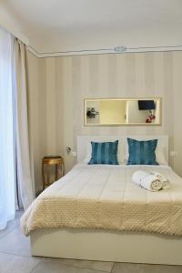 a bedroom with a large white bed with blue pillows at Triscele Glamour Rooms in Palermo