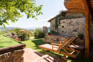 a patio with a bench and a stone fireplace at Villa Giulia a "Casa Conti di Sotto" in Gavorrano